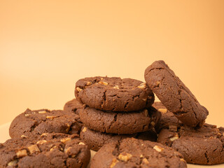 Chocolatey, rich cookies with contrasting white chocolate chips on an orange background. Cookies with white chocolate close-up.
