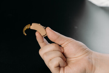 hearing aid on white background in hand, cochlear implant