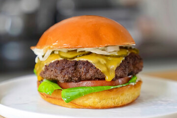 Burger beef cheese classic minimal close up. Hamburger freshly baked on white plate, homemade. Grocery product advertising, menu or package.