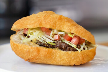 Burger beef cheese minimal close up. Hamburger freshly baked on white plate, homemade. Grocery product advertising, menu or package.