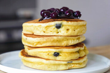 Pancakes fluffy stack with berries on white plate, delicious food. Homemade freshly baked pancakes...