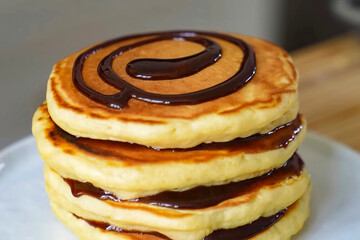 Pancakes fluffy stack with chocolate on white plate, delicious food. Homemade freshly baked pancakes for American breakfast, menu, advert or package, close up.