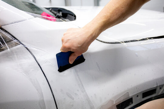 The process of installing PPF on a car. PPF is a protective film for paint that protects the paint from scratches and gravel.Anti-gravity protection. PFF is installed. Wrapping a car in close-up