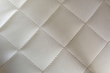 White leather texture background with rhomboid stitching.