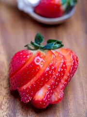 Sliced strawberry on wooden background.