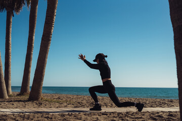 a girl doing exercises on the seashore in sportswear. fitness trainer girl doing exercise. There is space for writing text.