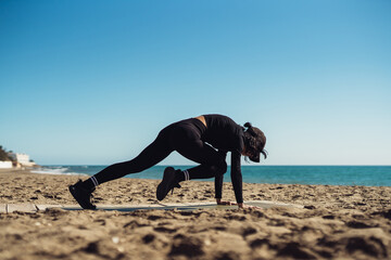 a girl doing exercises on the seashore in sportswear. fitness trainer girl doing exercise. There is space for writing text.