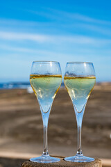 Pouring a glass of champagne on vacation, south of Fuerteventura, Canary islands, blue ocean, mountains