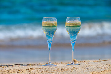 Fototapeta na wymiar Pouring a glass of champagne on vacation, south of Fuerteventura, Canary islands, blue ocean, mountains