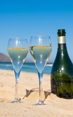 Pouring a glass of champagne on vacation, south of Fuerteventura, Canary islands, blue ocean, mountains