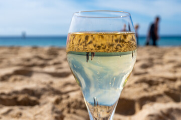 Pouring a glass of champagne on vacation, south of Fuerteventura, Canary islands, blue ocean, mountains