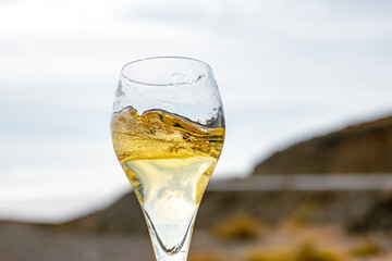 Pouring a glass of champagne on vacation, south of Fuerteventura, Canary islands, blue ocean, mountains
