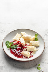 Lazy dumplings, vareniki with raspberry jam decorated with almond petals and mint leaves isolated. Boiled cottage cheese homemade gnocchi