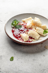 Lazy dumplings, vareniki with raspberry jam decorated with almond petals and mint leaves isolated. Boiled cottage cheese homemade gnocchi