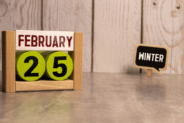 February 25 on wooden calendar, on dark gray background