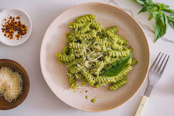 Pasta pesto, parmesan cheese, basil on plate. Delicious homemade pasta dish, serving food for restaurant, menu, advert or package, close up, selective focus
