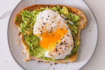 Avocado Toast with boiled Egg on plate. Healthy vegetarian breakfast, toasted bread with avocado, for menu, advert or package, selective focus. Top view