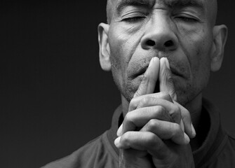 black man praying to god Caribbean man praying with black background with people stock photo	
