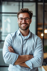 A Man in a Blue Shirt and Glasses Standing With Arms Crossed