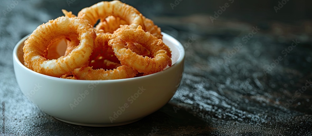 Aufkleber white bowl with onion rings on dark surface top view. copy space image. place for adding text