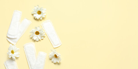Menstrual pads and beautiful chamomile flowers on light yellow background. Banner for design