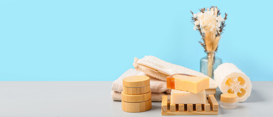 Set of bathing supplies and cosmetics on table against blue background. Banner for design