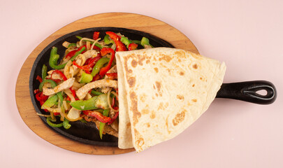 Delicious Sizzling Hot Chicken Fajitas with Peppers and Onions at Mexican Restaurant