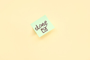 Sticky note with word DONE and check mark on beige background