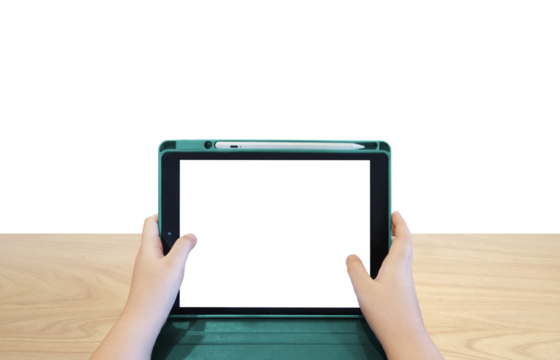 Boy's hands holding a tablet on a wooden table PNG transparent