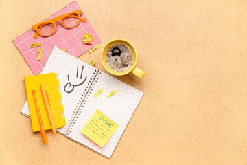 Sticky note with word DONE, stationery, coffee cup and eyeglasses on beige background