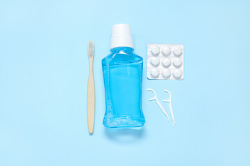 Chewing gums with toothbrush, mouthwash and floss on blue background