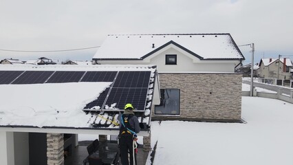 Technician engineer working on power outage blackout on solar panel during a winter snowstorm....