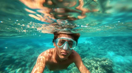 Foto op Plexiglas Young man snorkeling in clear tropical turqoise waters © Nikodem