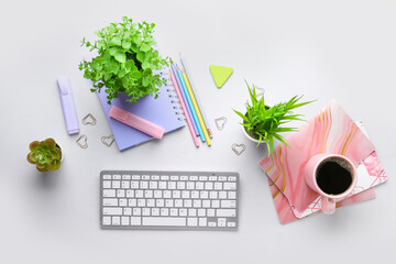 Composition with modern computer keyboard, cup of coffee, houseplants and stationery on white...