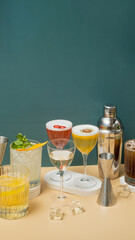 Composition with alcoholic cocktails and bar tools on podiums on colored background. Copy space.