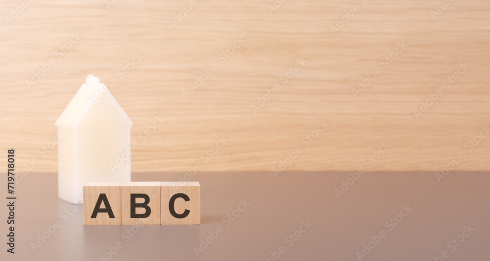 Poster cubes form the word abc on a light background there is a row of cubes and a toy house in the backgro