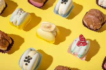 Set of different macaroons on yellow background top view, flat lay. Luxury sweets.