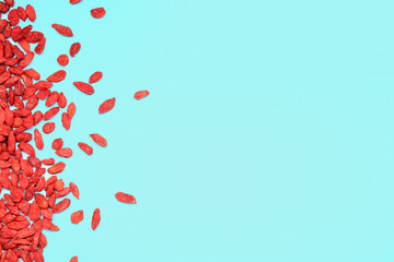 Red dried goji berries on blue background