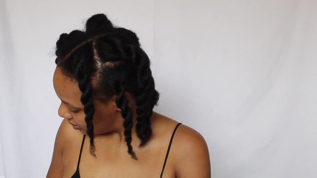 Black woman twisting her natural 4c hair on a white background