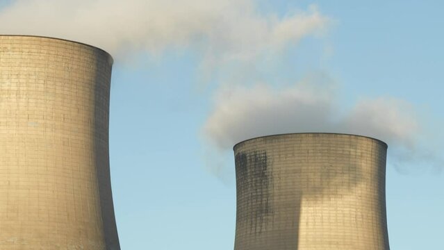 CLOSE UP: Evaporation of steam from the cooling towers of thermal power plant in Ratcliffe On Soar. Tall concrete structure and questionable emissions during the production of electricity with coal.