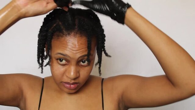 Black woman twisting her natural 4c hair on a white background