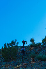 Dos hombres corriendo hacia la cima de una montaña