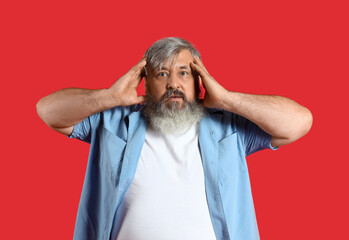 Afraid mature man on red background
