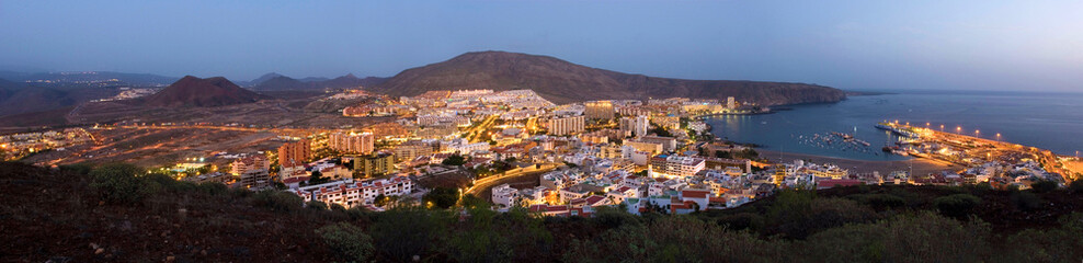 Los Cristianos in the evening at sunset, blue hour, panoramic shot with harbor, volcanoes and sea,...