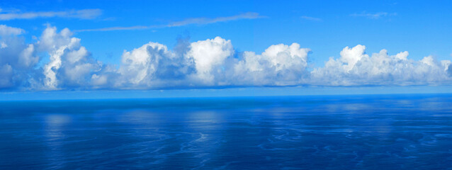 View over the blue Atlantic Ocean with white clouds, panoramic shot, from the mountain slopes near...