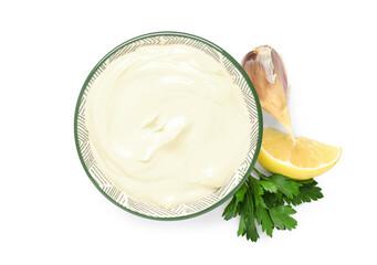 Bowl of fresh mayonnaise with parsley, garlic and lemon on white background