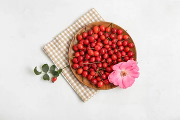 Foto op Plexiglas Wooden plate with fresh rose hip berries and flower on white background © Pixel-Shot