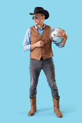 Cool mature cowboy with disco ball on blue background