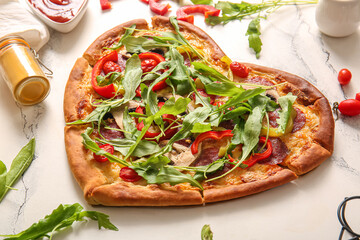 Tasty heart shaped pizza and ingredients on white background