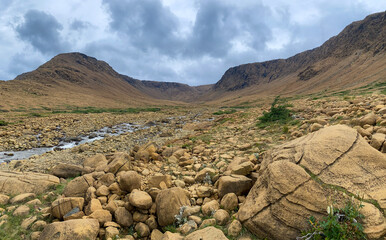 Tablelands in Gros Morne National Park, a Canadian national park and World Heritage Site in Newfoundland. An area where earth's mantle is exposed, peridotite rocks rich with iron rust, waterfall.